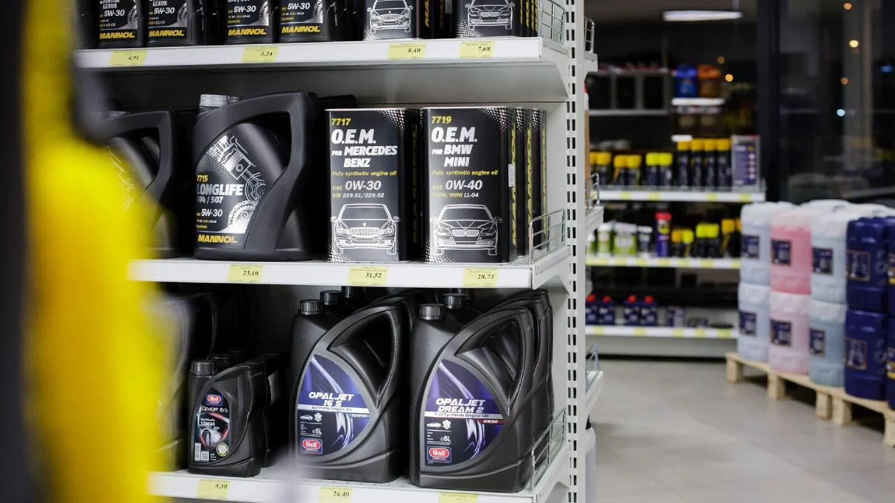Rows of automotive fluid bottles on a shelf in a workshop
