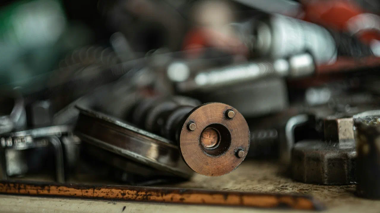 A close-up of a metal tool on a workbench in a busy garage