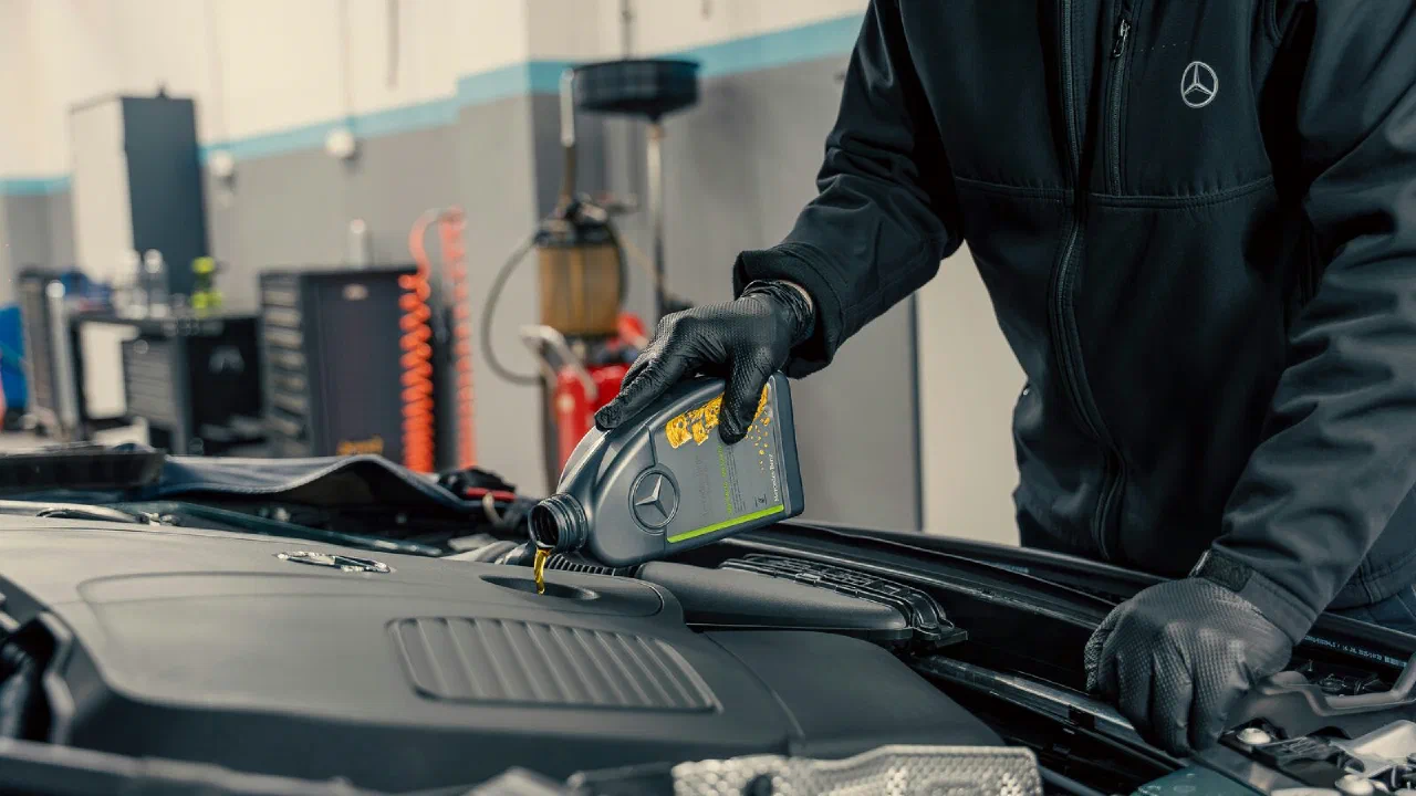 Oil being poured from a bottle into a car engine