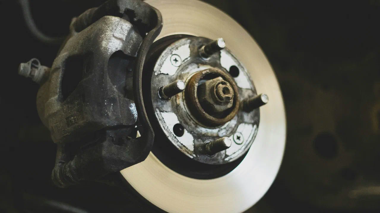 A brake disc and caliper assembly seen through the spokes of a wheel