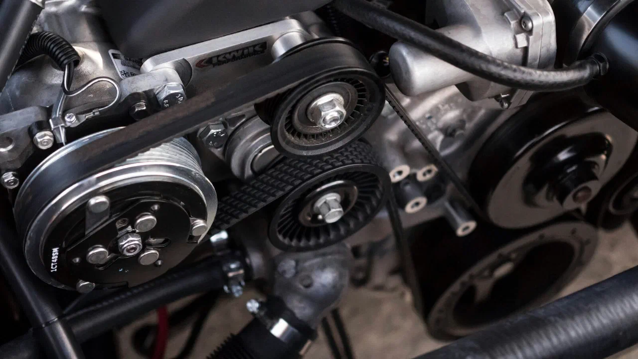 A car engine bay with belts and pulleys visible